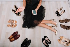 zena usedecem polozaju okruzena raznim modelima obuce