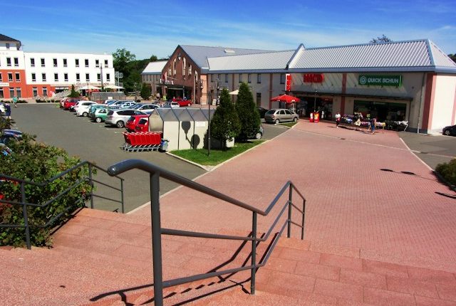 Stepenište sa metalnom ogradom koje vodi do parkinga i ulaza u tržni centar