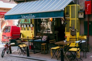 Terasa kafića Vanilla sa plavom tendom i žutim stolicama