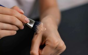 Devojka četkicom uzima puder sa ruke