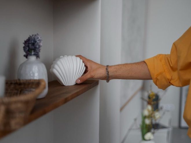 Žena stavlja figuricu na policu