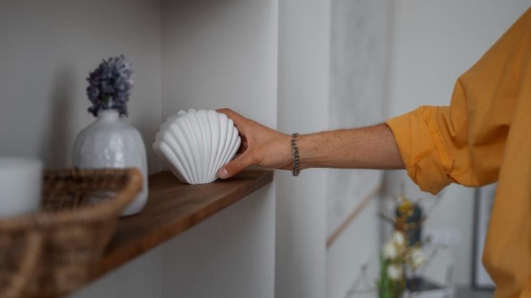 Žena stavlja figuricu na policu